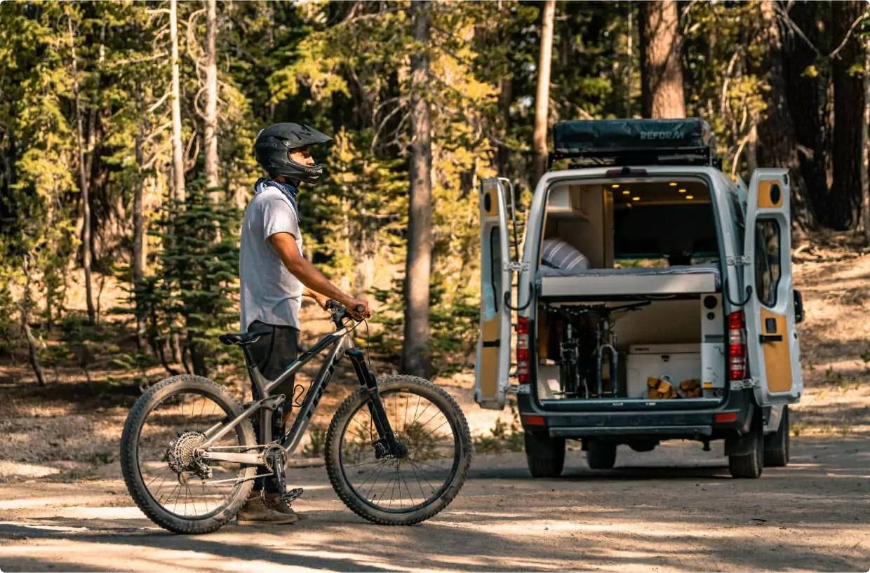 mountain biker standing infront of camper van